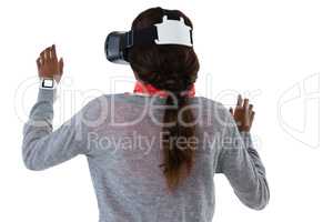 Rear view of young woman gesturing while using vr glasses