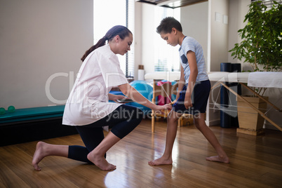 Side view of female therapist examining boy