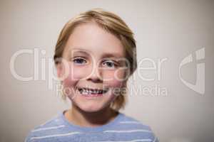 Close-up portrait of smiling boy against wall