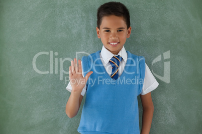 Schoolboy raising hand in classroom
