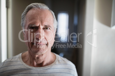 Close-up portrait of senior male patient standing in corridor