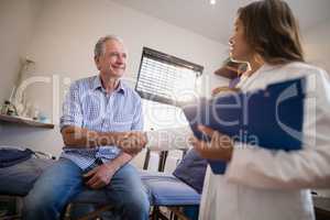 Low angle view of female therapist and senior male patient shaking hands