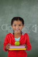 Young girl holding apple and books