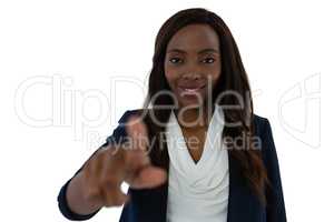 Smiling young businesswoman touching imaginary screen