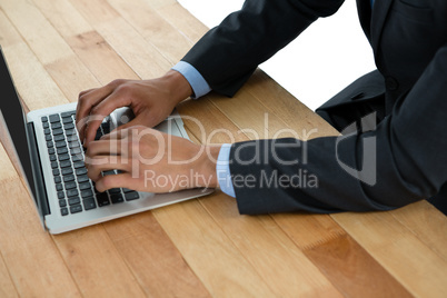 Mid section of businessman using laptop