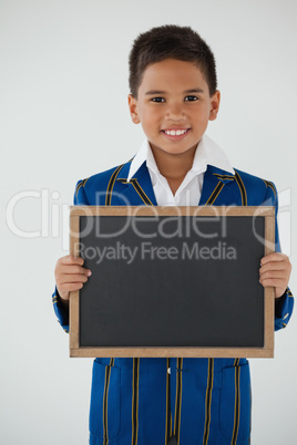 Schoolboy holding blank writing slate against white background