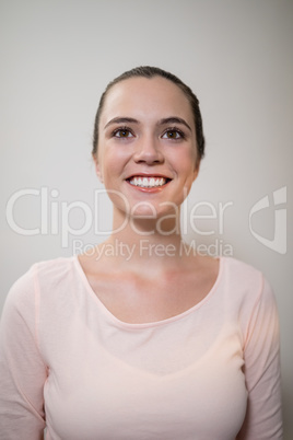 Smiling young female therapist looking away against wall