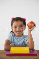 Schoolgirl holding a red apple against white background