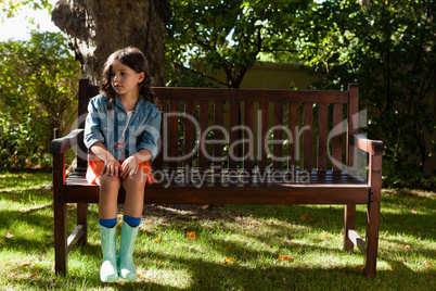 Girl wearing casual sitting on wooden bench