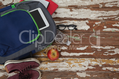 Bagpack, water bottle, apple, digital tablet, shoes and spectacle