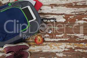 Bagpack, water bottle, apple, digital tablet, shoes and spectacle