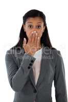 Surprised businesswoman covering her mouth with hand