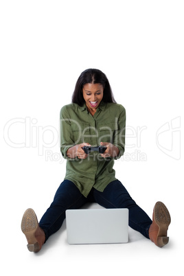 Woman playing video game on laptop against white background