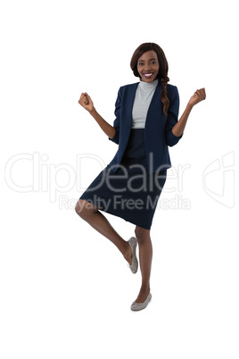 Portrait of happy businesswoman standing on one leg