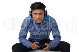 Portrait of young businessman wearing headphones playing video game