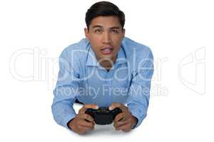 Young businessman lying down while playing video game
