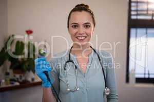 Portrait of smiling young female therapist holding ultrasound machine