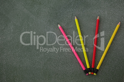 Various pencils with eraser arranged on chalkboard