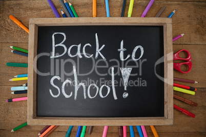 Text written on slate surrounded with school supplies