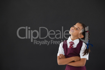 Schoolgirl standing against blackboard in classroom