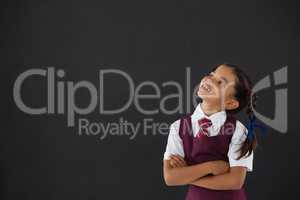 Schoolgirl standing against blackboard in classroom