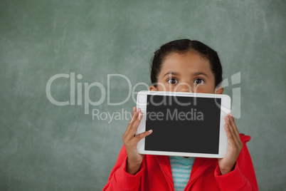 Young girl holding digital tablet against her face