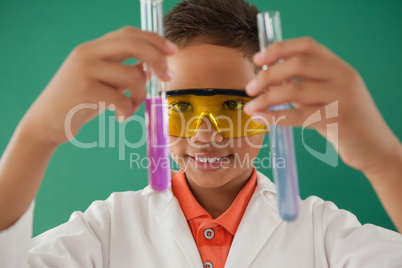 Schoolboy experimenting against green background