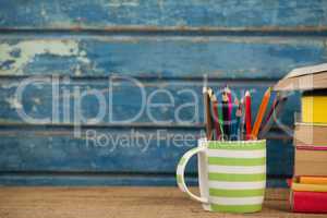 Pen holder against blue wooden background