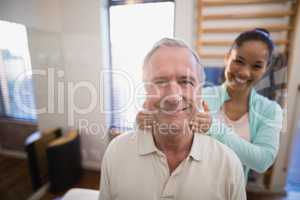 Portrait of smiling senior male patient and female therapist