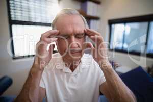 Senior male patient holding head during headache