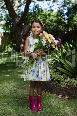 Portrait of smiling girl holding flowers bouquet