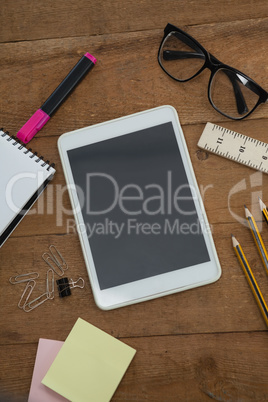 School supplies, digital tablet and spectacles on wooden table