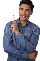 Portrait of smiling businessman holding pen