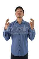 Businessman with crossed fingers looking up