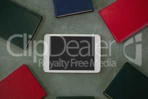 Digital tablet surrounded with colorful organizers on chalkboard