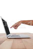 Hand pointing at laptop screen