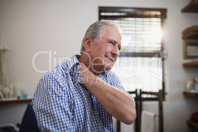 Senior male patient grimacing with neck pain