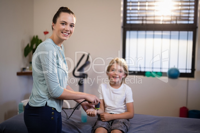 Portrait of smiling boy with female therapist scanning wrist