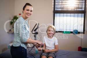 Portrait of smiling boy with female therapist scanning wrist