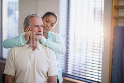 Senior male patient receiving neck massage from female therapist
