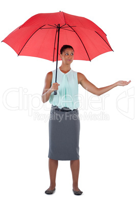 Businesswoman standing under a red umbrella