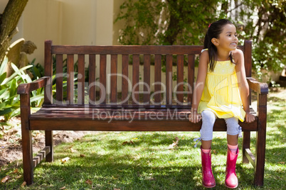 Smiling girl sitting on wooden bench