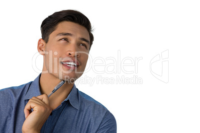 Close up of thoughtful businessman holding pen while looking away