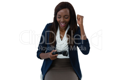 Happy businesswoman playing video game