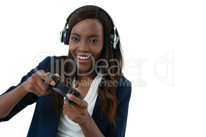 Happy businesswoman playing video game wearing headphones while playing video game