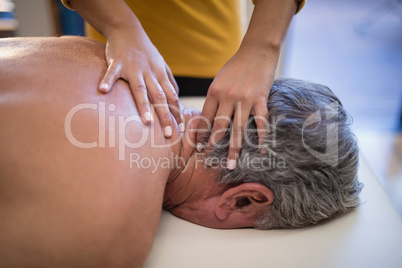 High angle view of female therapist giving neck massage to male patient