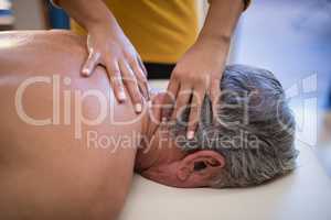 High angle view of female therapist giving neck massage to male patient