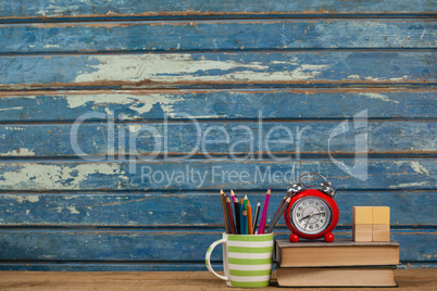 School supplies, alarm clock and wooden blocks on table