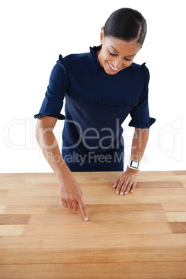 Businesswoman touching invisible screen on wooden table