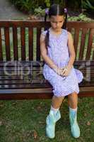 High angle view of upset girl sitting on wooden bench
